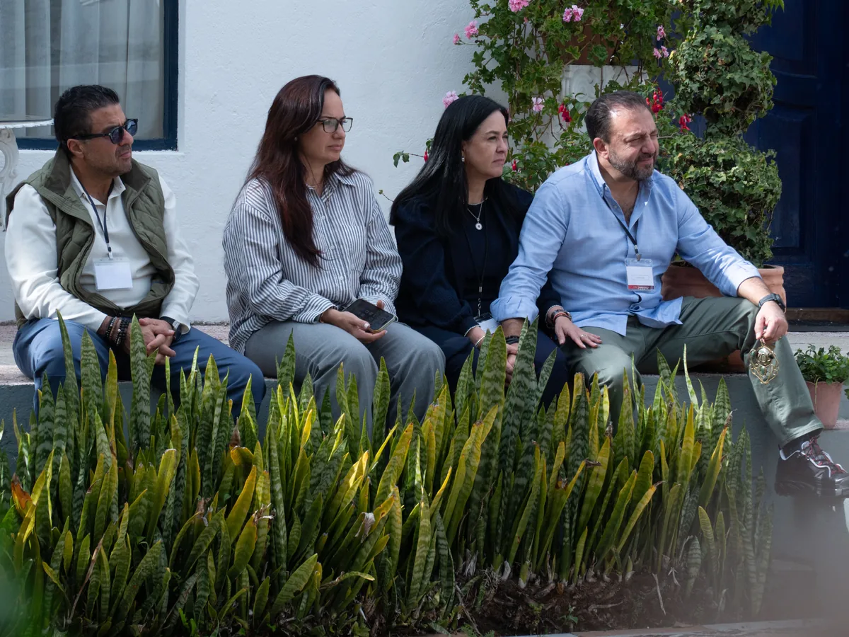 Cuatro participantes conversan en el jardín
